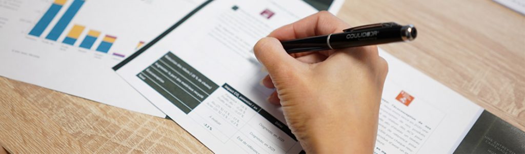 Un main annote le rapport RSE avec un stylo Coulidoor